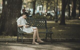 girl reading on bench